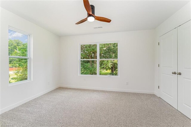 4000 Groometown Rd, Greensboro, NC 27407 - unfurnished bedroom with multiple windows, light carpet, and a closet
