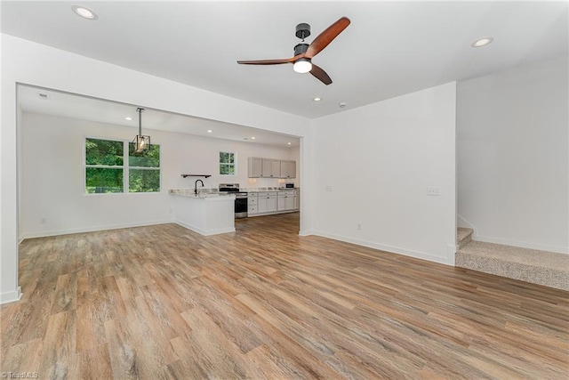 4000 Groometown Rd, Greensboro, NC 27407 - unfurnished living room with a ceiling fan, light wood-style floors, recessed lighting, and stairs