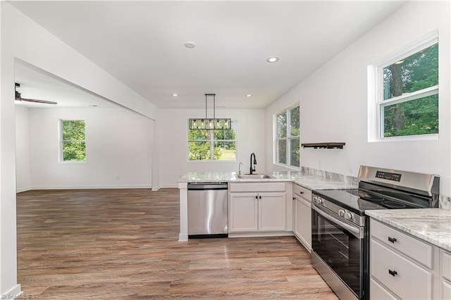 4000 Groometown Rd, Greensboro, NC 27407 - kitchen featuring appliances with stainless steel finishes, light wood-style floors, white cabinets, recessed lighting, and a peninsula