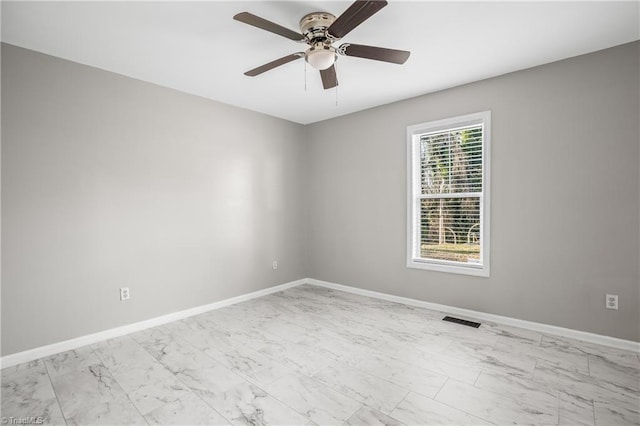 unfurnished room with marble finish floor, baseboards, visible vents, and a ceiling fan