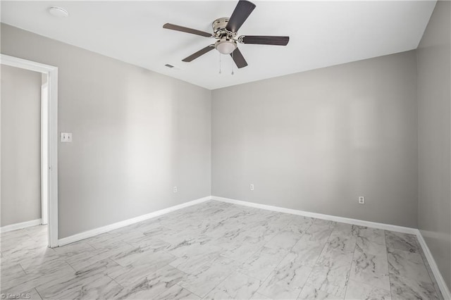 empty room featuring marble finish floor, baseboards, visible vents, and a ceiling fan