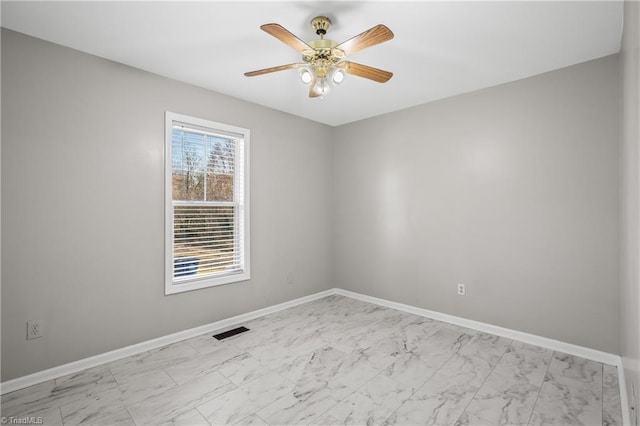 spare room featuring ceiling fan, marble finish floor, visible vents, and baseboards