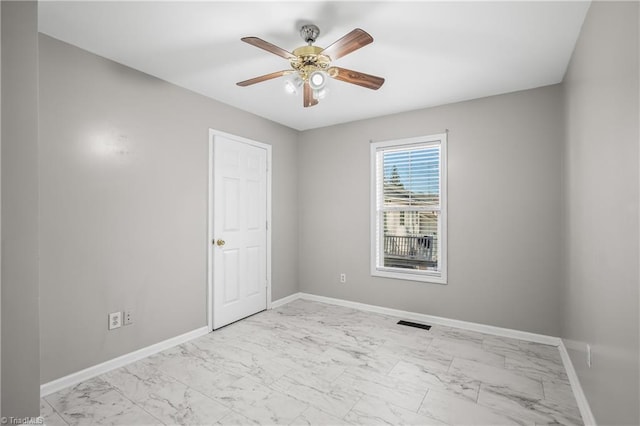 unfurnished room with marble finish floor, visible vents, and baseboards