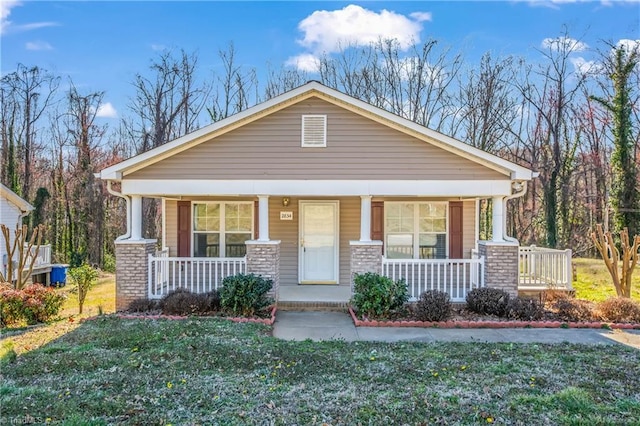 craftsman-style house featuring covered porch and a front lawn