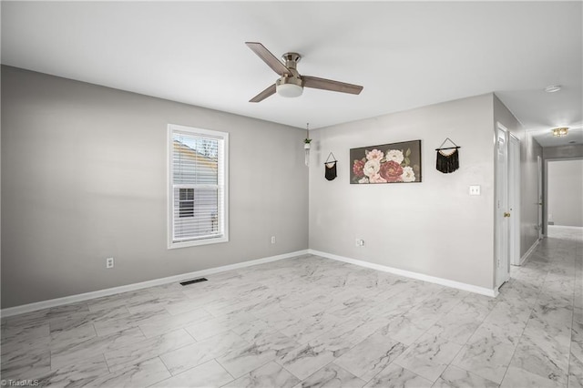 empty room featuring marble finish floor, visible vents, and baseboards