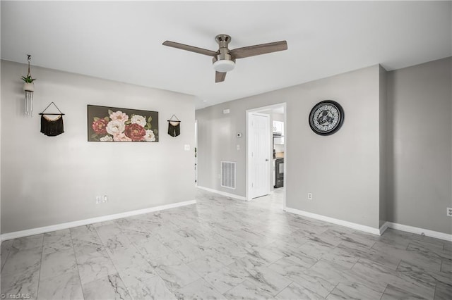 empty room featuring ceiling fan, marble finish floor, visible vents, and baseboards