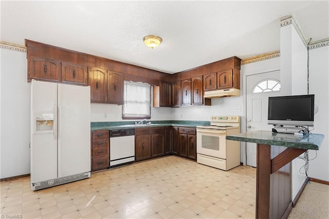 kitchen with white appliances, light floors, under cabinet range hood, a textured ceiling, and dark countertops