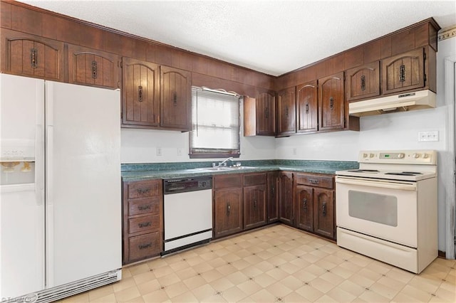 kitchen with dark countertops, under cabinet range hood, light floors, white appliances, and a sink