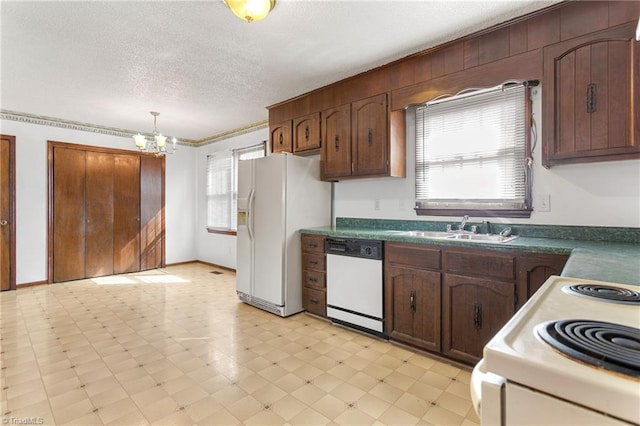 kitchen featuring white appliances, light floors, a sink, a textured ceiling, and a chandelier