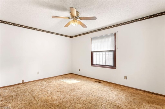 carpeted empty room featuring visible vents, baseboards, a textured ceiling, and ceiling fan