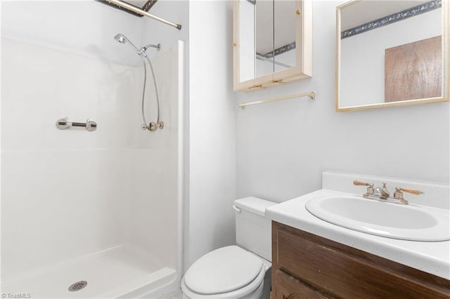 bathroom with toilet, a stall shower, and vanity