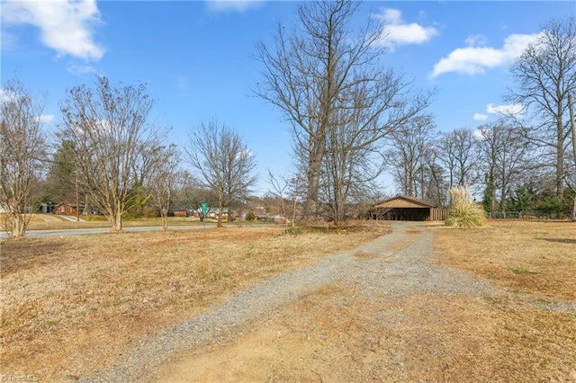 view of street with gravel driveway and a pole building