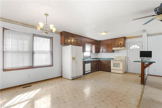 kitchen featuring white appliances, visible vents, under cabinet range hood, a textured ceiling, and decorative light fixtures