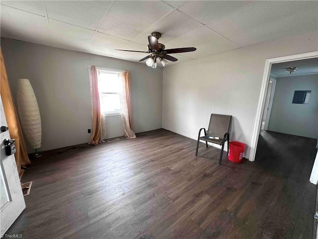 empty room with ceiling fan, a paneled ceiling, and dark hardwood / wood-style flooring