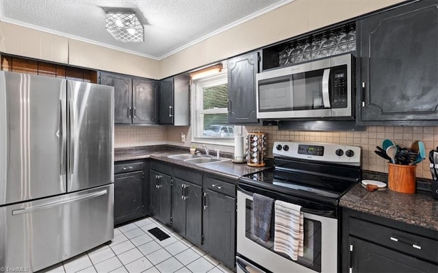 kitchen featuring light tile patterned flooring, sink, appliances with stainless steel finishes, and ornamental molding