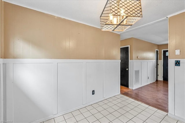 empty room featuring light wood-type flooring and an inviting chandelier