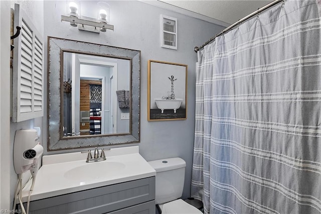 bathroom featuring a textured ceiling, vanity, and toilet