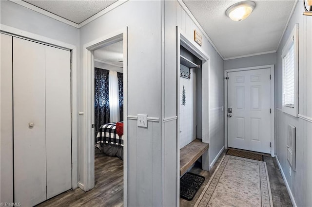 mudroom featuring hardwood / wood-style floors, a textured ceiling, and ornamental molding