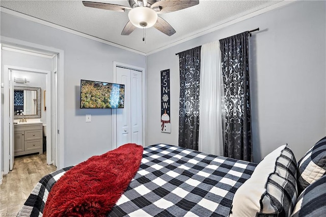 bedroom featuring a closet, a textured ceiling, ceiling fan, and light wood-type flooring