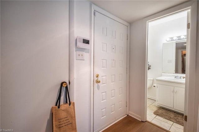 doorway with light tile patterned flooring and sink