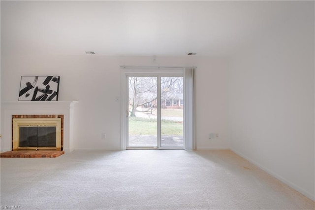 unfurnished living room with a brick fireplace and carpet