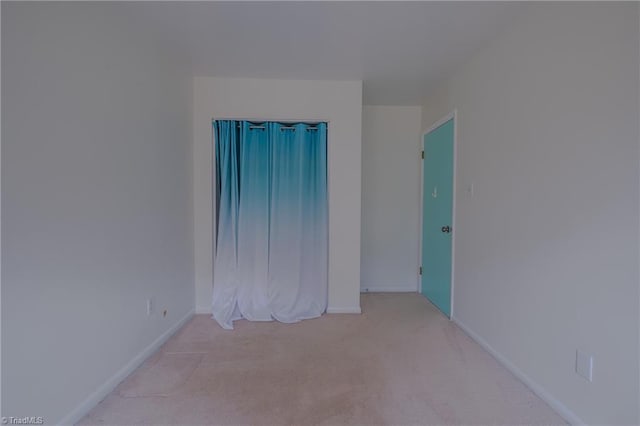 unfurnished room featuring light colored carpet