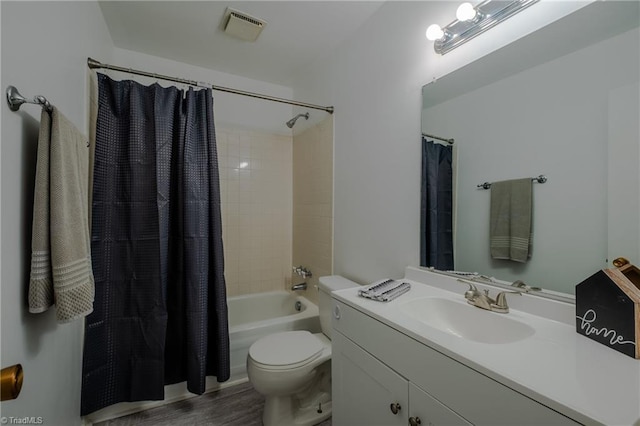 full bathroom with hardwood / wood-style flooring, shower / tub combo with curtain, vanity, and toilet