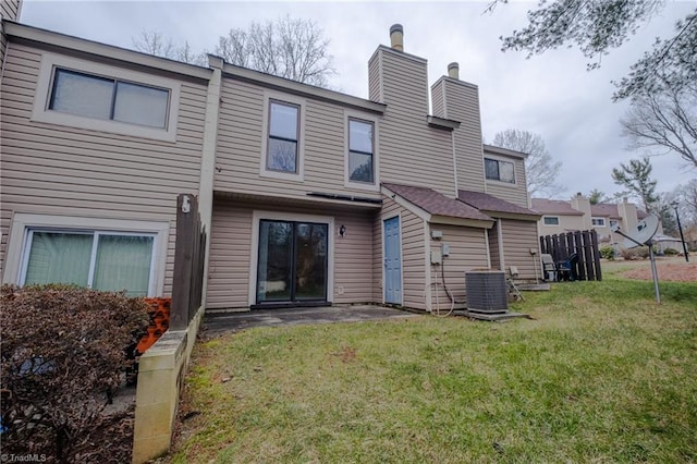 back of property with a lawn and central air condition unit