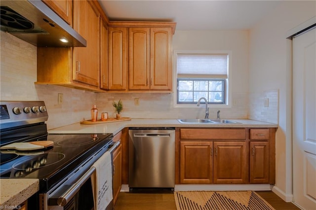 kitchen with tasteful backsplash, sink, stainless steel appliances, and light wood-type flooring