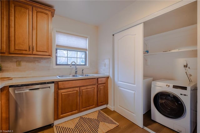 washroom featuring sink, washer / dryer, and light hardwood / wood-style flooring