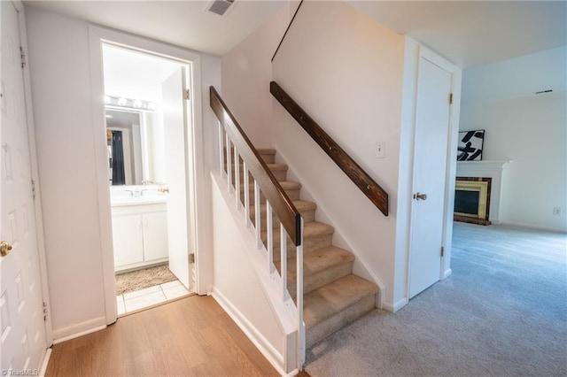 stairway with sink and hardwood / wood-style floors