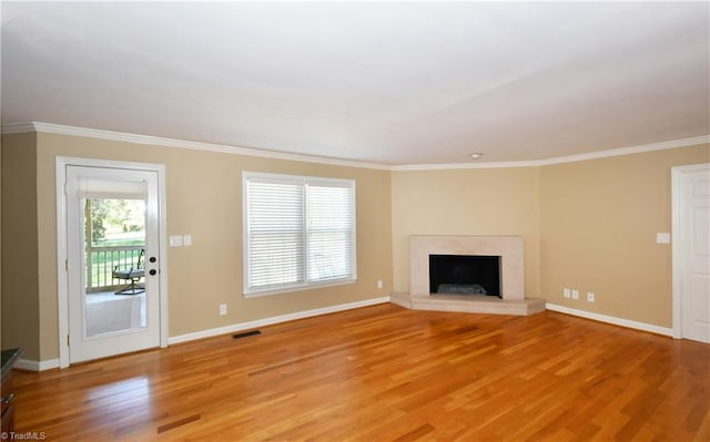 unfurnished living room featuring ornamental molding and light wood-type flooring