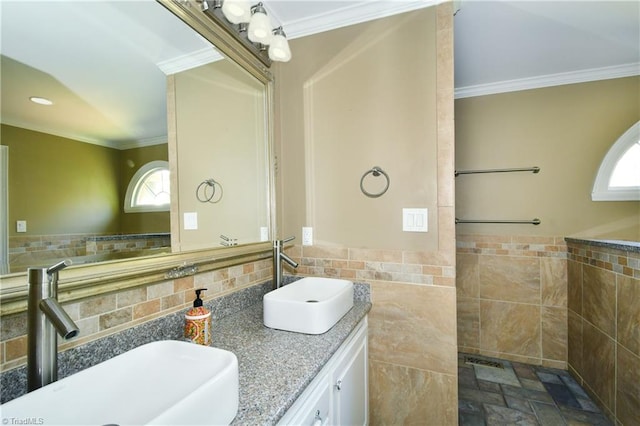 bathroom with ornamental molding, a healthy amount of sunlight, tile walls, and vanity