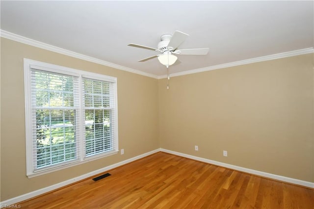 empty room featuring crown molding, hardwood / wood-style flooring, and ceiling fan