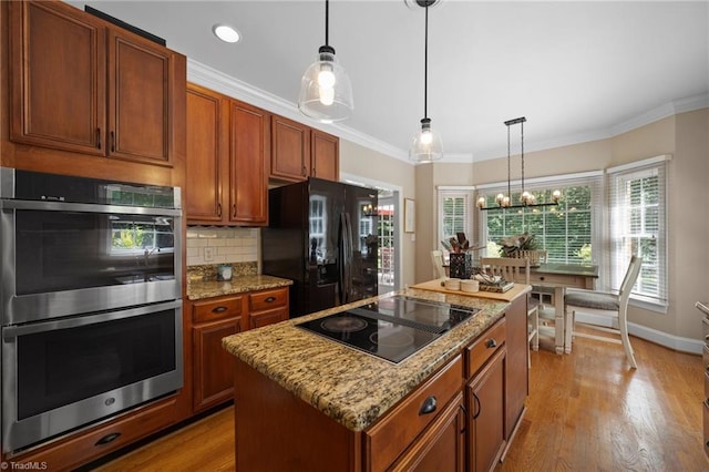 6303 Reata Ct, Summerfield, NC 27358 - kitchen with black appliances, a center island, tasteful backsplash, ornamental molding, and decorative light fixtures