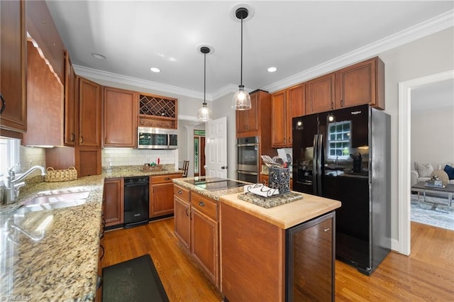 6303 Reata Ct, Summerfield, NC 27358 - kitchen with black appliances, a kitchen island, decorative backsplash, light wood finished floors, and light stone counters
