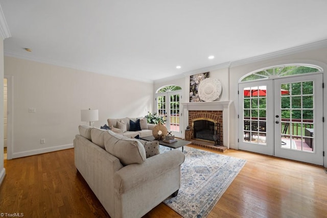 6303 Reata Ct, Summerfield, NC 27358 - living area featuring french doors, crown molding, wood finished floors, a brick fireplace, and recessed lighting