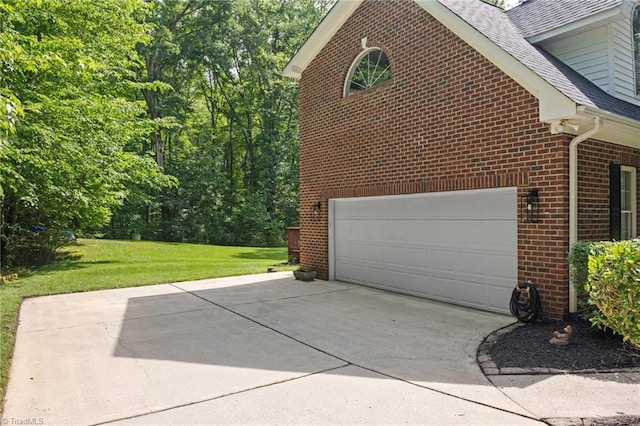 6303 Reata Ct, Summerfield, NC 27358 - view of home's exterior with brick siding, driveway, a lawn, a shingled roof, and a garage