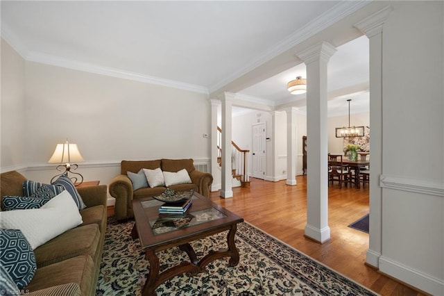 6303 Reata Ct, Summerfield, NC 27358 - living area featuring ornate columns, wood finished floors, crown molding, stairway, and a chandelier