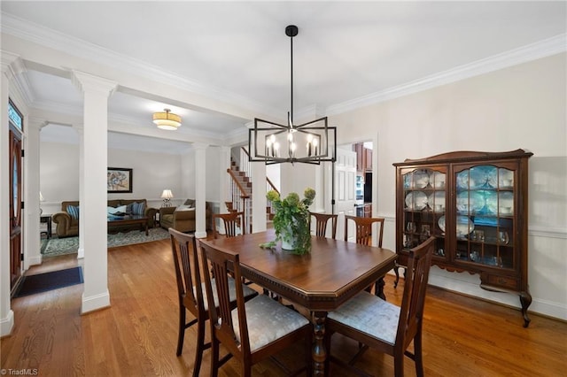 6303 Reata Ct, Summerfield, NC 27358 - dining area with decorative columns, light wood-type flooring, ornamental molding, a chandelier, and stairs