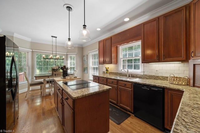 6303 Reata Ct, Summerfield, NC 27358 - kitchen featuring black appliances, light wood-style flooring, ornamental molding, a center island, and light stone countertops