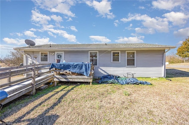 back of house with a deck and a lawn