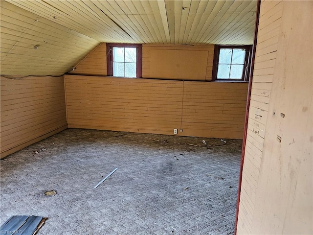 additional living space featuring wooden ceiling, carpet, wooden walls, and vaulted ceiling