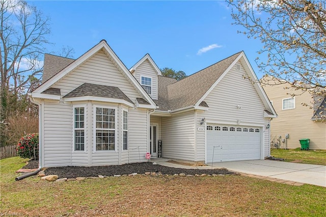 traditional-style home with a front lawn, roof with shingles, concrete driveway, and an attached garage