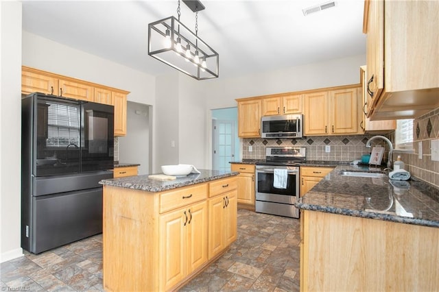 kitchen with light brown cabinetry, visible vents, stainless steel appliances, and a sink