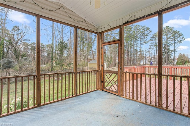 unfurnished sunroom with lofted ceiling and a ceiling fan