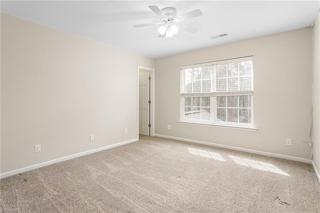 carpeted empty room featuring visible vents, baseboards, and a ceiling fan