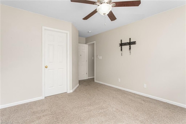 unfurnished bedroom with light carpet, ceiling fan, and baseboards