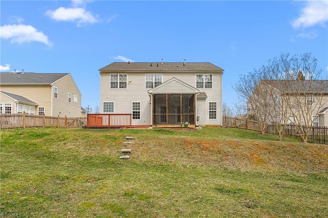 back of property featuring a yard, a deck, a fenced backyard, and a sunroom