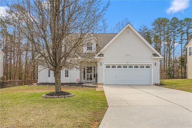 view of front of house with a front yard, concrete driveway, fence, and an attached garage